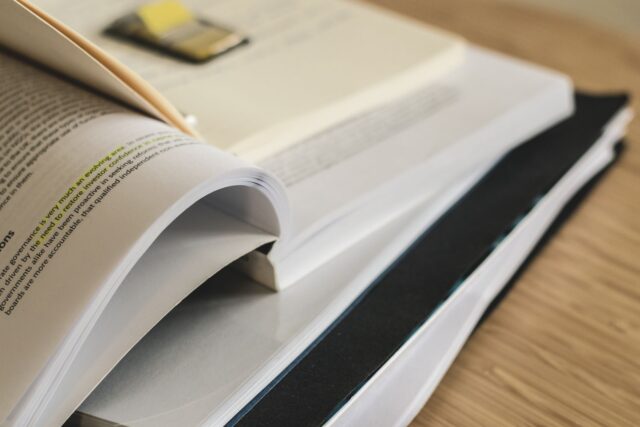 Rafturi de bibliotecă cu cărți vechi, legate în piele, așezate în rânduri ordonate