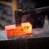 Rândunele așezate pe o sârmă, pe fundalul unui cer senin de primăvară